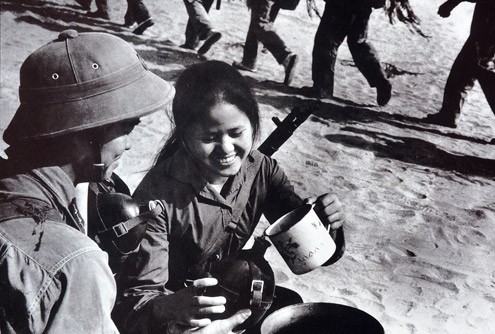 Cuộc chiến chống Mỹ cuối thập niên 50 của quân và dân Việt Nam trải qua bao gian khổ. Trong đó vẫn có nhiều khoảnh khắc cả chiến đấu lẫn khi đời thường được các phóng viên chiến trường ghi lại. Trong ảnh là một o dân quân rót nước chia sẻ cho các anh bộ đội.